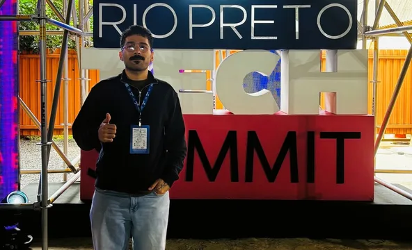 Elias de corpo inteiro diante do letreiro do Rio Preto Tech Summit.